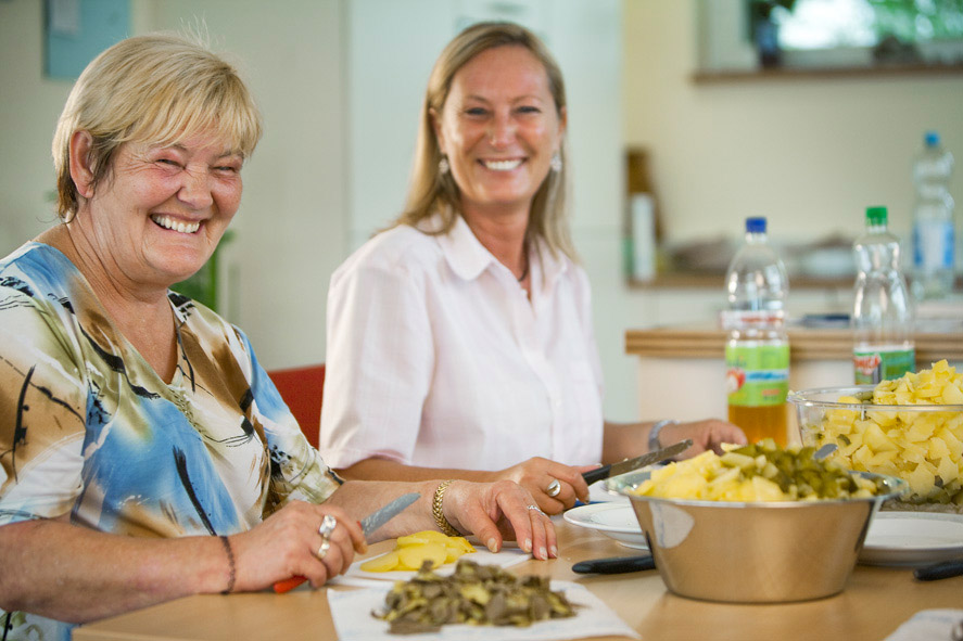 Zwei Frauen, die zusammen in der Küche stehen und einen Kartoffelsalat zubereiten