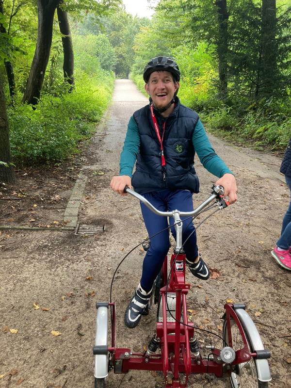 Ein Mann fährt auf einem Fahrrad mit drei Rädern