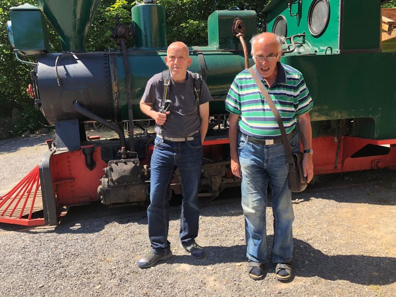 Bei den Karl-May-Festspielen Zwei Männer stehen vor einer Lokomotive