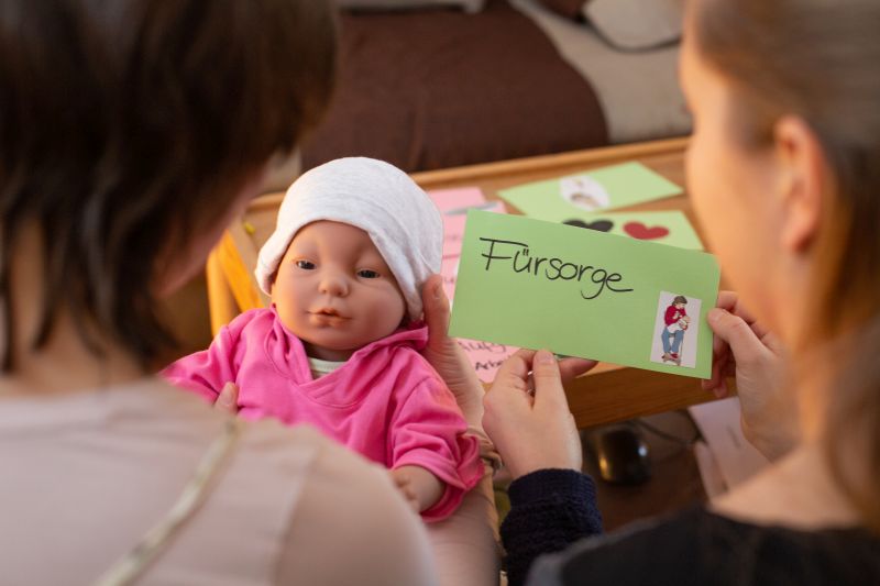 Zwei Frauen von hinten, die sich gemeinsam Karten ansehen, auf denen steht was gut und was schlecht im Elternpraktikum gelaufen ist.