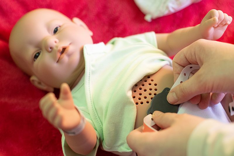 Nahaufnahme des Baby-Simulators, der mit einem Chip am Bauch aktiviert wird.