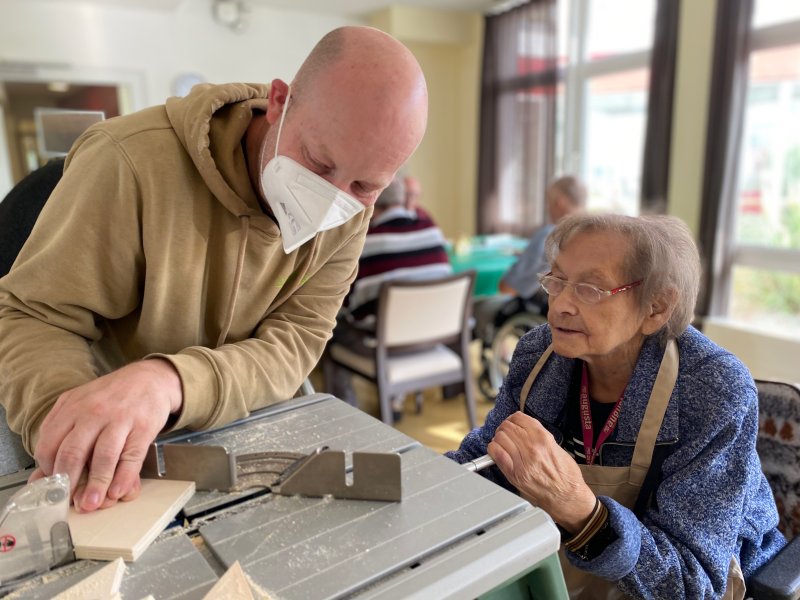 Ein Mann und eine Frau schneiden etwas aus Holz aus