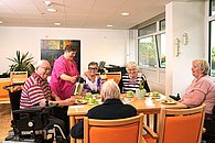 Bewohner*innen sitzen zusammen beim Kaffeetrinken