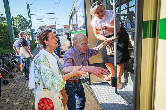 Gemeinsam geschafft: Die Stufe ins Innere der Oldtimer-Bahn meistert Bernd Kreickenbaum mit Unterstützung von Petra-Ilona Gobrecht (l.) vom Inner Wheel Club und Hausleiterin Renata Schlichting.  Foto: Sarah Jonek