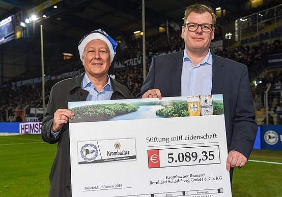 Scheckübergabe mit Pastor Dr. Ingo Habenicht vom Evangelischen Johanneswerk im Stadion der Arminia Bielefeld