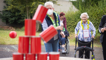 Dosenwerfen bei der Augenblick-Olympiade Eine Bewohnerin und eine Mitarbeiterin sind beim Dosenwerfen.