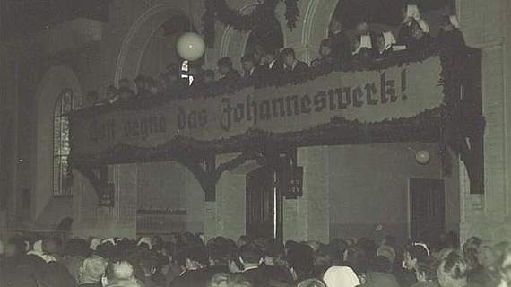 Menschen halten Banner "Bollwerk gegen die Not"