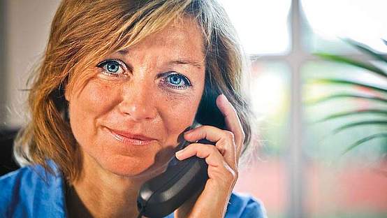 Eine Frau mit einem Telefonhörer am Ohr