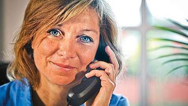 Eine Frau mit einem Telefonhörer am Ohr