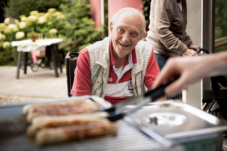 Senior freut sich auf ein leckeres, gegrilltes Würstchen Senior freut sich auf ein leckeres, gegrilltes Würstchen