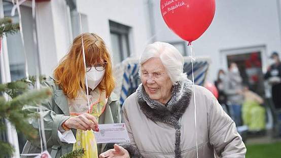 Zwei Frauen, die eine Karte an einem Ballon in der Hand halten