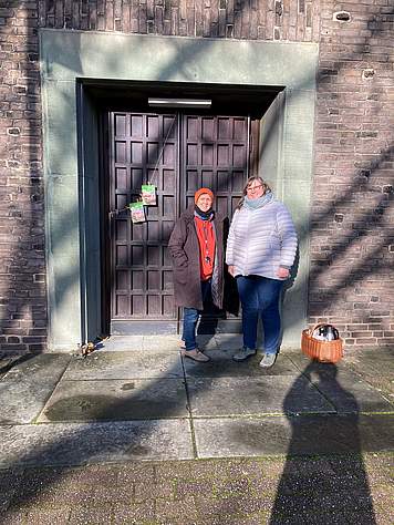 Zwei Frauen stehen vor der Tür von der Kirche