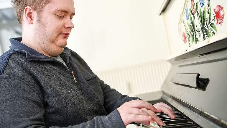 Daniel spielt Klavier in der Werkstatt für Menschen mit Autismus in Schalksmühle, Evangelisches Johanneswerk