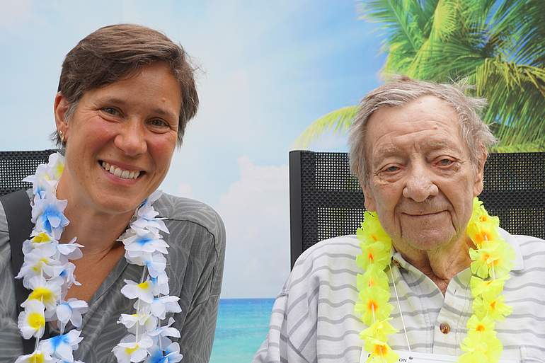 Urlaubsfotos zum Erinnern Zwei Frauen haben eine Hawaii-Kette um und lächeln in die Kamera