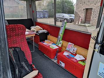 In dem Bus stehen Kisten, Tablets und Flyer