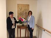 Zwei Frauen stehen neben einem Strauß Blumen