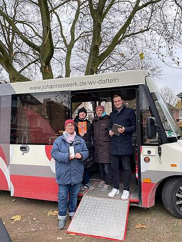 Vier Menschen stehen vor dem Jo-Mobil-Bus