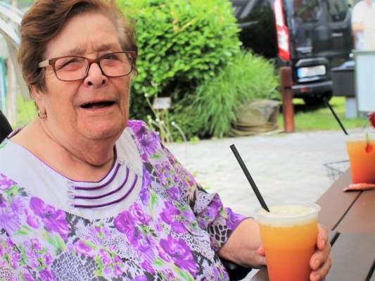 Eine ältere Frau mit einem Cocktailglas in der Hand